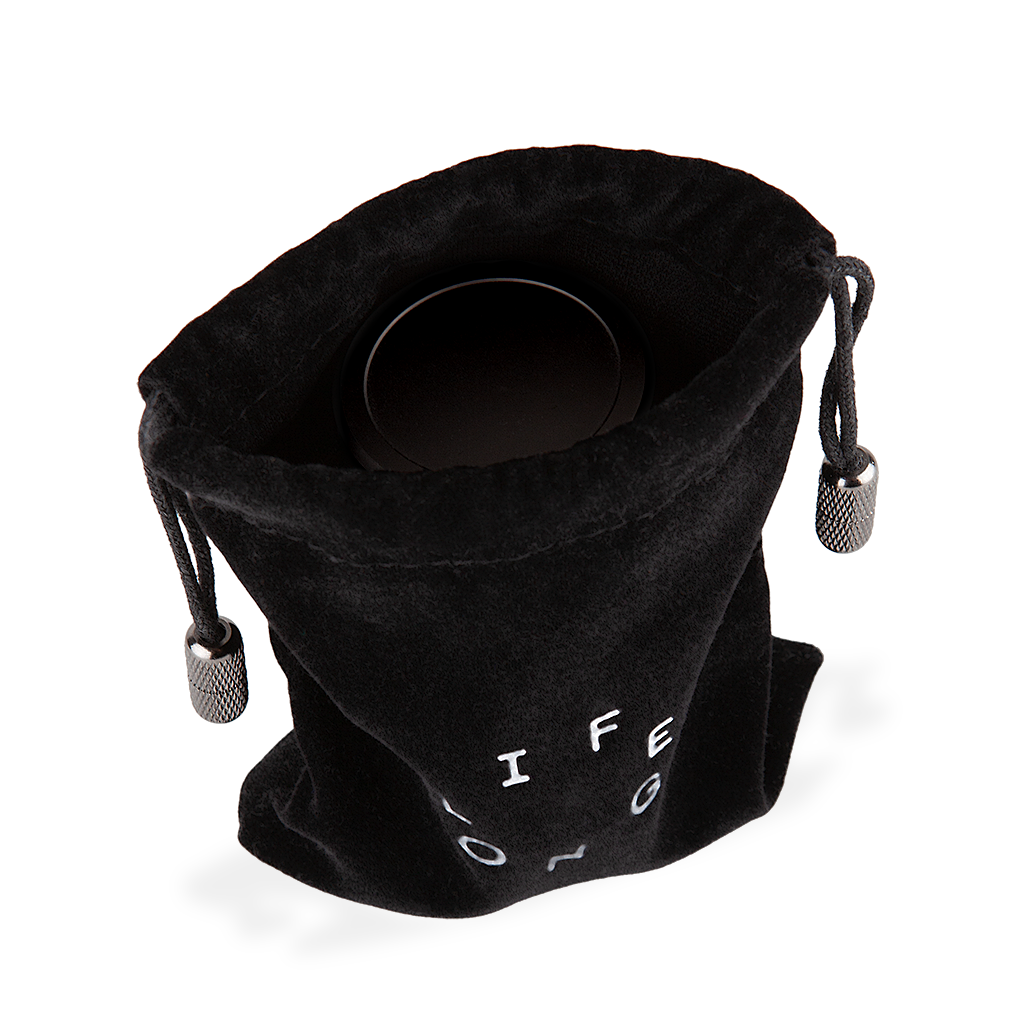 Black travel bag for refillable deodorant from the brand Lifelongdeo. Bag is velvet with a circle white logo saying Lifelong. The straps has knurled metal details in the ends. You can see the deodorant in the bag.