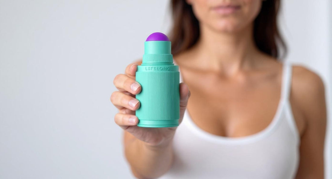 A person holding a deodorant stick in their hand, with soft lighting and a neutral background.